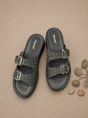 Pair of black sandals with buckles on a beige background