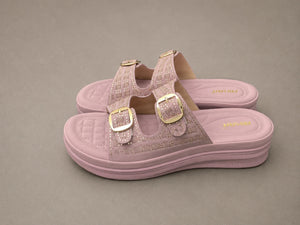 Pink jelly sandals with gold buckles on a gray background