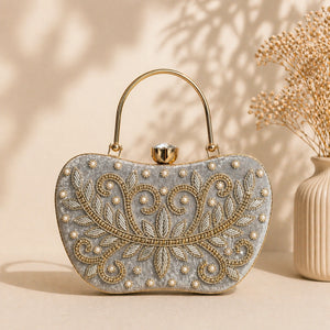 Decorative handbag with intricate gold embroidery on a beige background