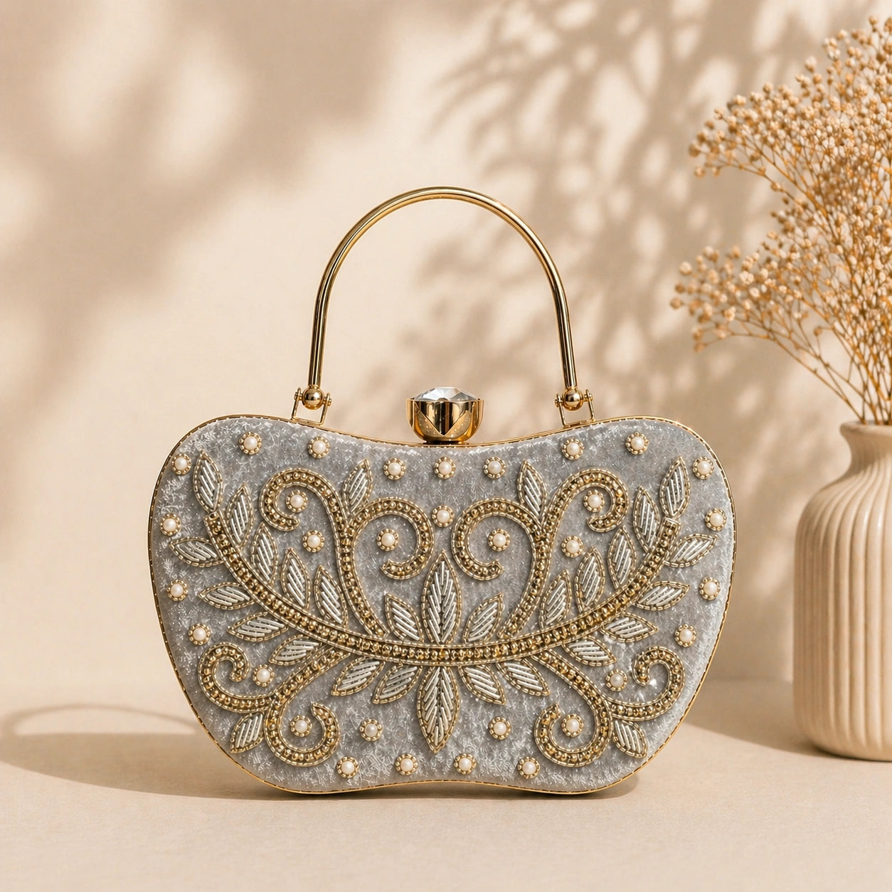 Decorative handbag with intricate gold embroidery on a beige background