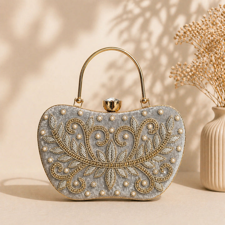 Decorative handbag with intricate gold embroidery on a beige background