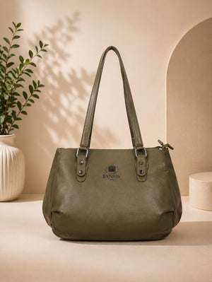 Green handbag on a beige surface with a neutral background
