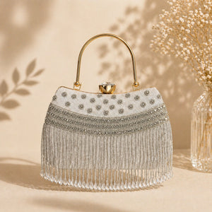 Elegant handbag with beaded details and fringe on a beige background