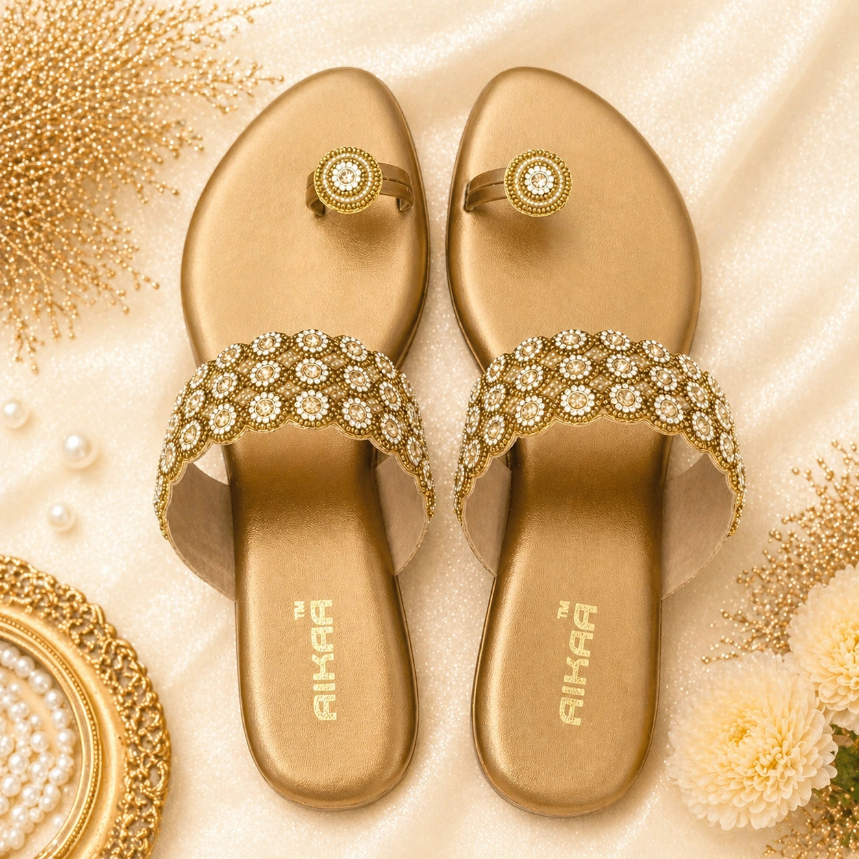 Pair of gold sandals with decorative straps on a decorative background