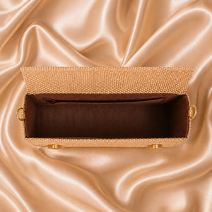 Gold clutch bag on a satin surface