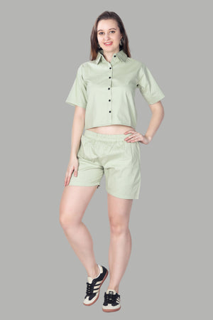 Woman wearing a light green shirt and shorts set on a gray background